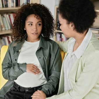 A pregnant patient holds her baby.