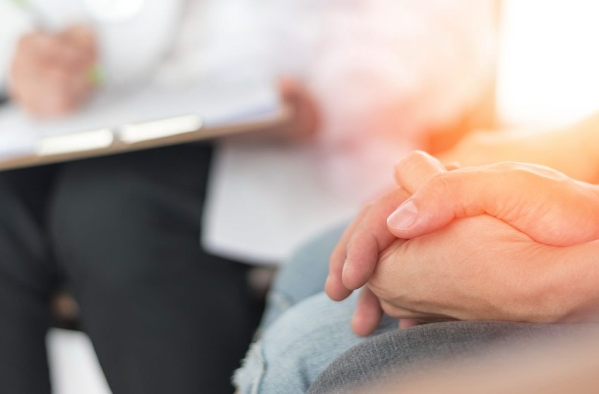 A couple holds hands while waiting for the pregnancy results